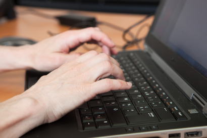 Des mains tapant sur un clavier d'ordinateur portable