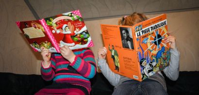 Deux fillettes lisent des livres. Leur visage est caché