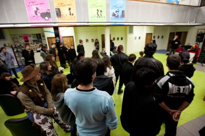 Un groupe de gens qui écoute quelqu'un qui parle au micro.