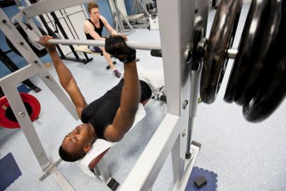 Un étudiant soulève des poids dans la salle de musculation