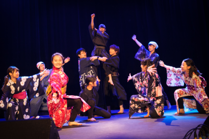 Un groupe de japonais en costume exécute une danse.