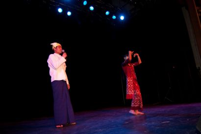 Deux personnes chantent et dansent en costume traditionnel.
