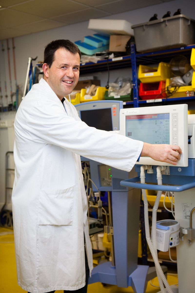 Un homme pose devant une machine au service biomédical du CHU.