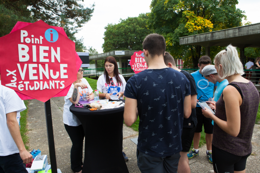 Un stand d'accueil avec des panneaux indiquant "bienvenue aux étudiants"