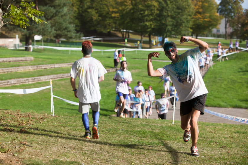 Une course, l'étudiant en tête couvert de poudre bleue fait signe au photographe