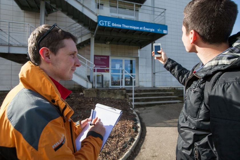 Deux étudiants en train d'examiner un bâtiment.