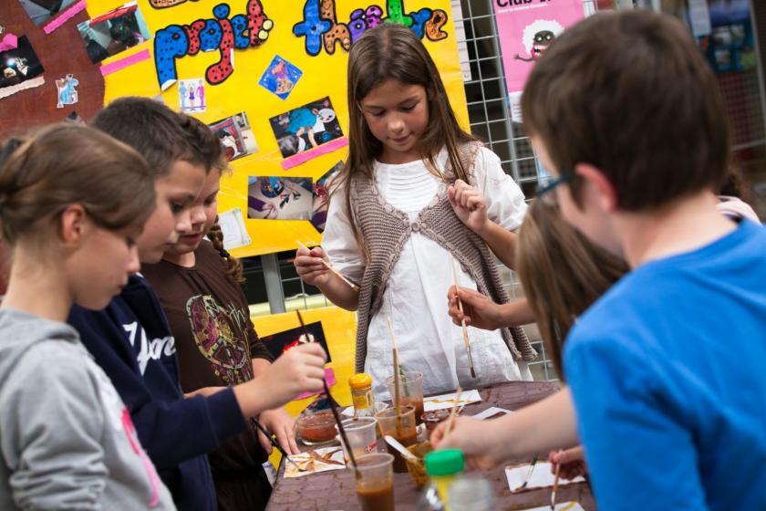 Plusieurs enfants font de la peinture.