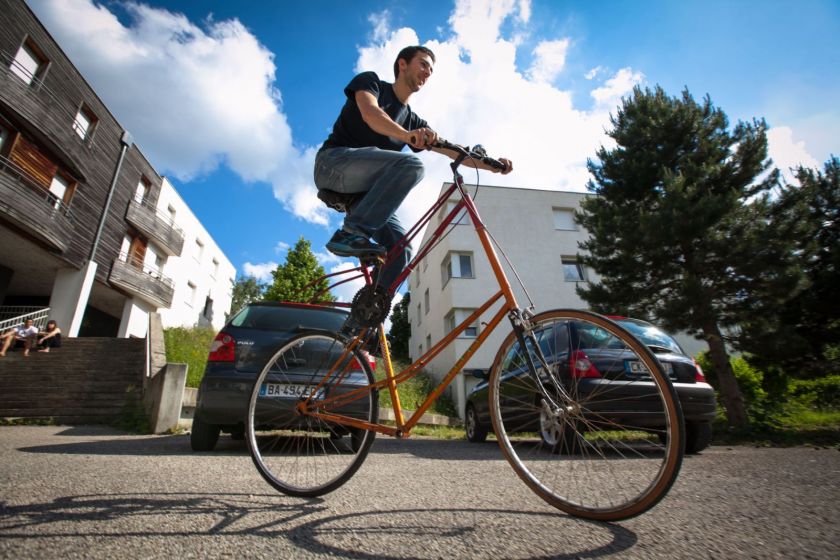 Un jeune homme sur un vélo au cadre très haut.