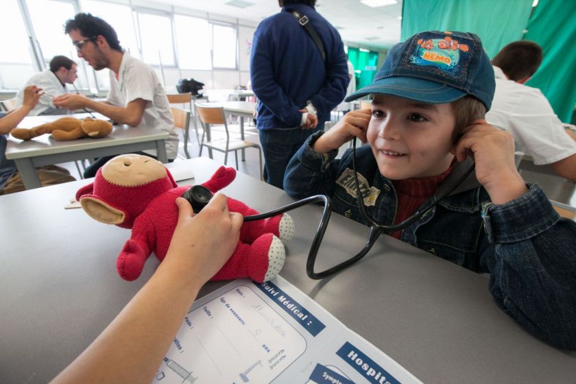 Un petit garçon à casquette écoute le coeur de son nounours au stéthoscope