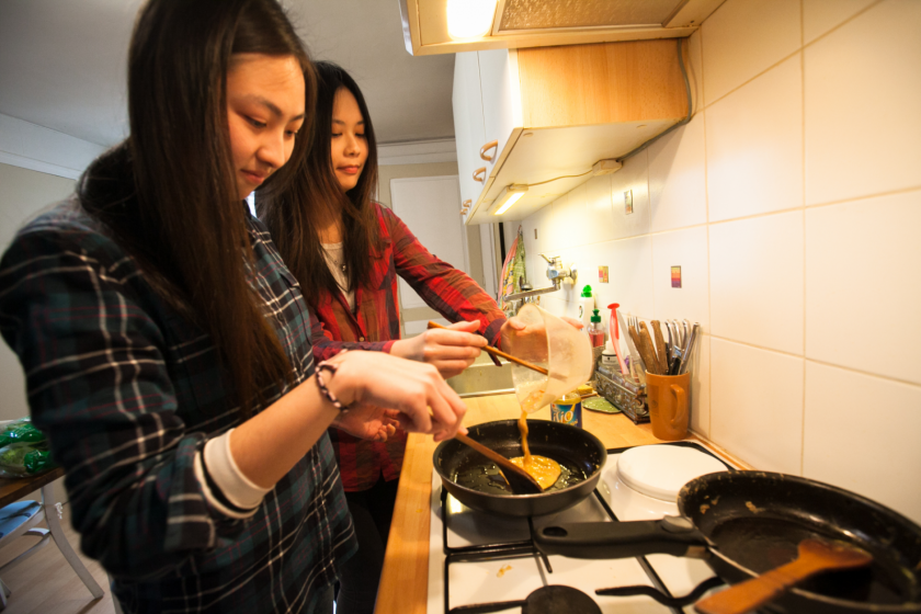 Deux étudiantes taïwanaises en train de mettre une omelette dans une poele.