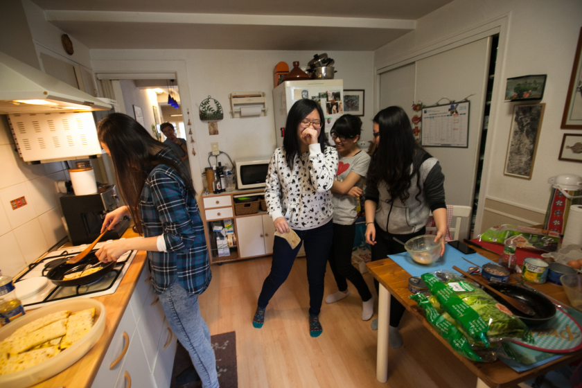 Quatre jeune tawanaises dans une cuisine en train de préparer des omelettes et de la salade.