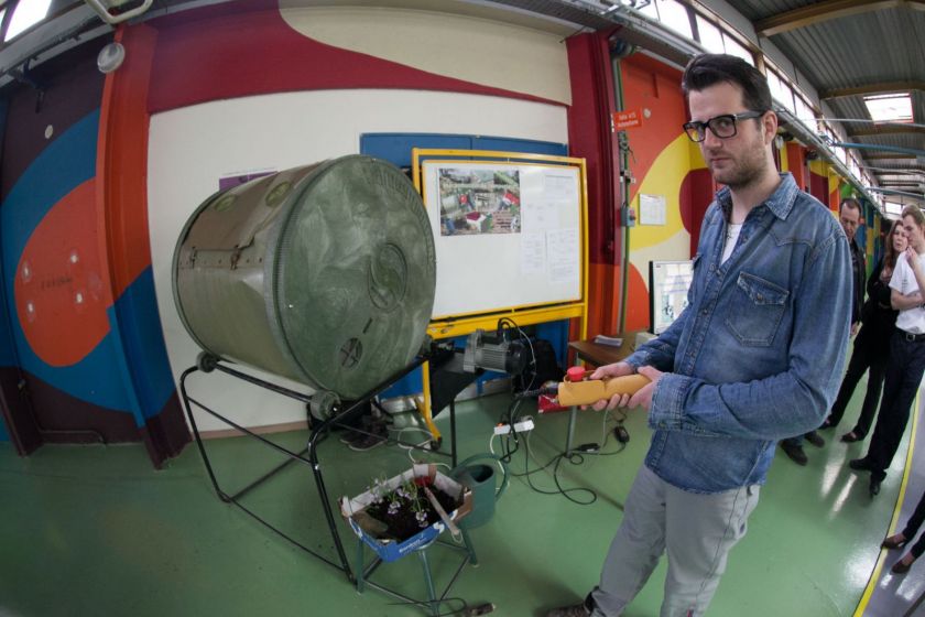 Un étudiant présente une machine à compost.