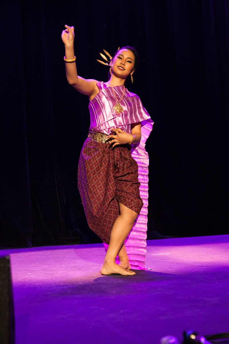 Une jeune fille en costume traditionel thailandais exécute une danse.