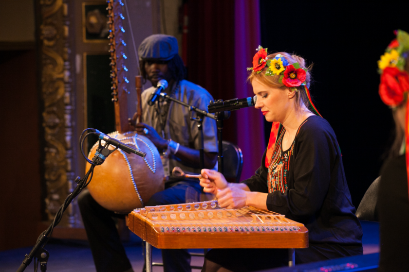 Une jeune femme biélorusse en costume joue du cymbalum.