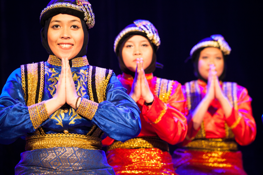 Trois jeunes femmes indonésiennes en costume traditionnelle exécutent une danse.