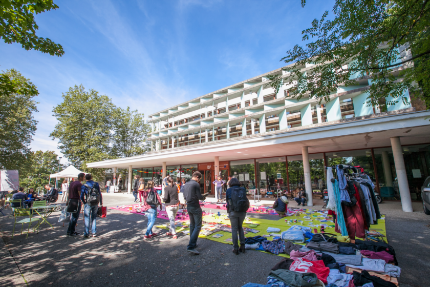 Vue large du parvis de la bibliothèque universitaire droit sur laquelle a été installée une sorte de brocante.  