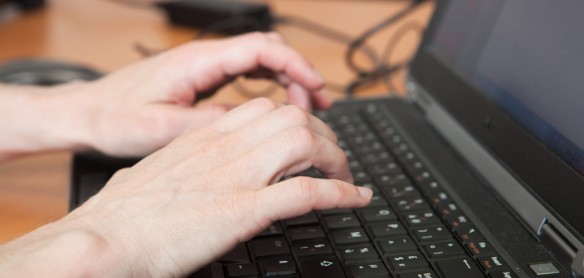 Des mains tapant sur un clavier d'ordinateur portable