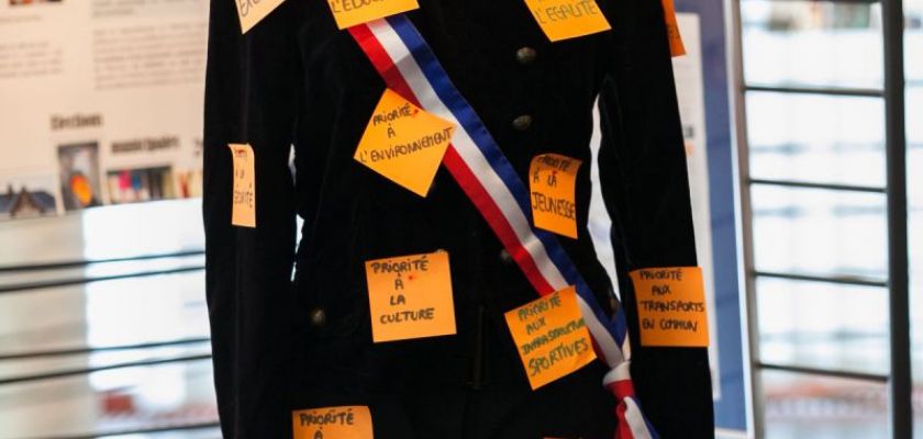 Un mannequin en habits officiels de maire avec des post it.