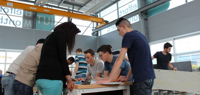 Des étudiants autour d'une table dans un atelier.