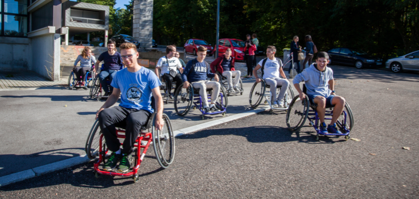 Des étudiants en fauteuil roulant devant la Maison des étudiants sur le campus de la Bouloie