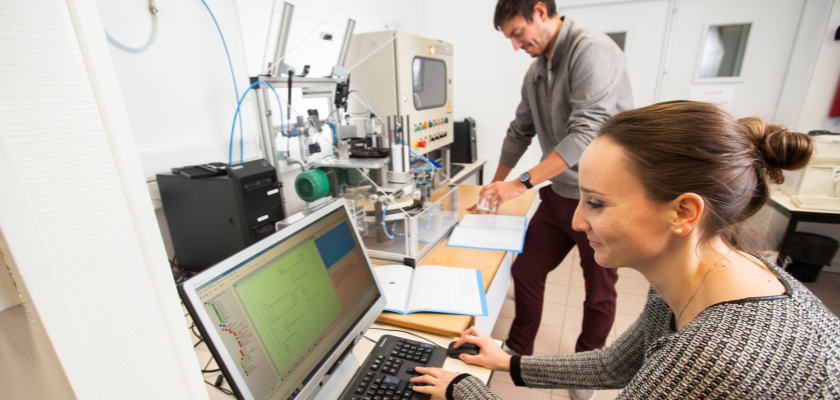 Deux étudiants devant une machine à encapsuler