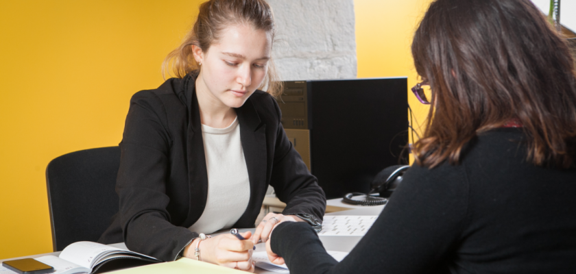 Une situation de travail avec deux jeunes femmes dans un bureau.