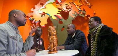 Quatre étudiants africains en train de discuter autour d'une table.