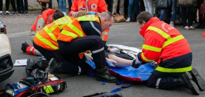 Des pompiers et la croix rouge lors d'une simulation d'accident devant un public.