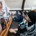 Une femme en train de parler à un groupe d'étudiants dans un amphithéâtre.