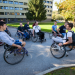 Un groupe d'étudiants en fauteuil roulant en train de discuter en extérieur.