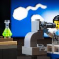 Bonhomme Légo chercheur qui regarde dans un microscope